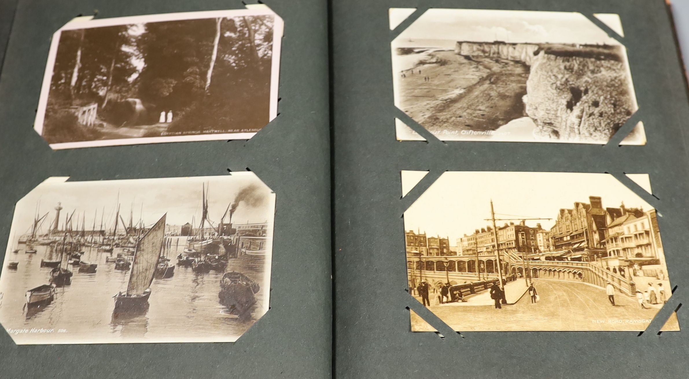 An Edwardian green postcard album, mounted with 68 risqué cards and a brown album mounted with Edwardian, George V and later, mainly topographical cards (2)